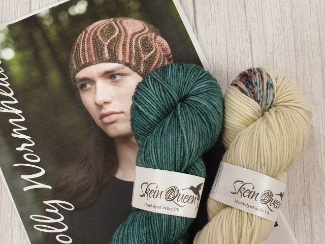 Photo of a hat pattern and two skeins of yarn